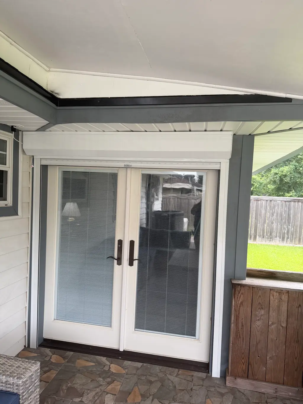 A rolling hurricane security shutter closed over a set of French patio doors
