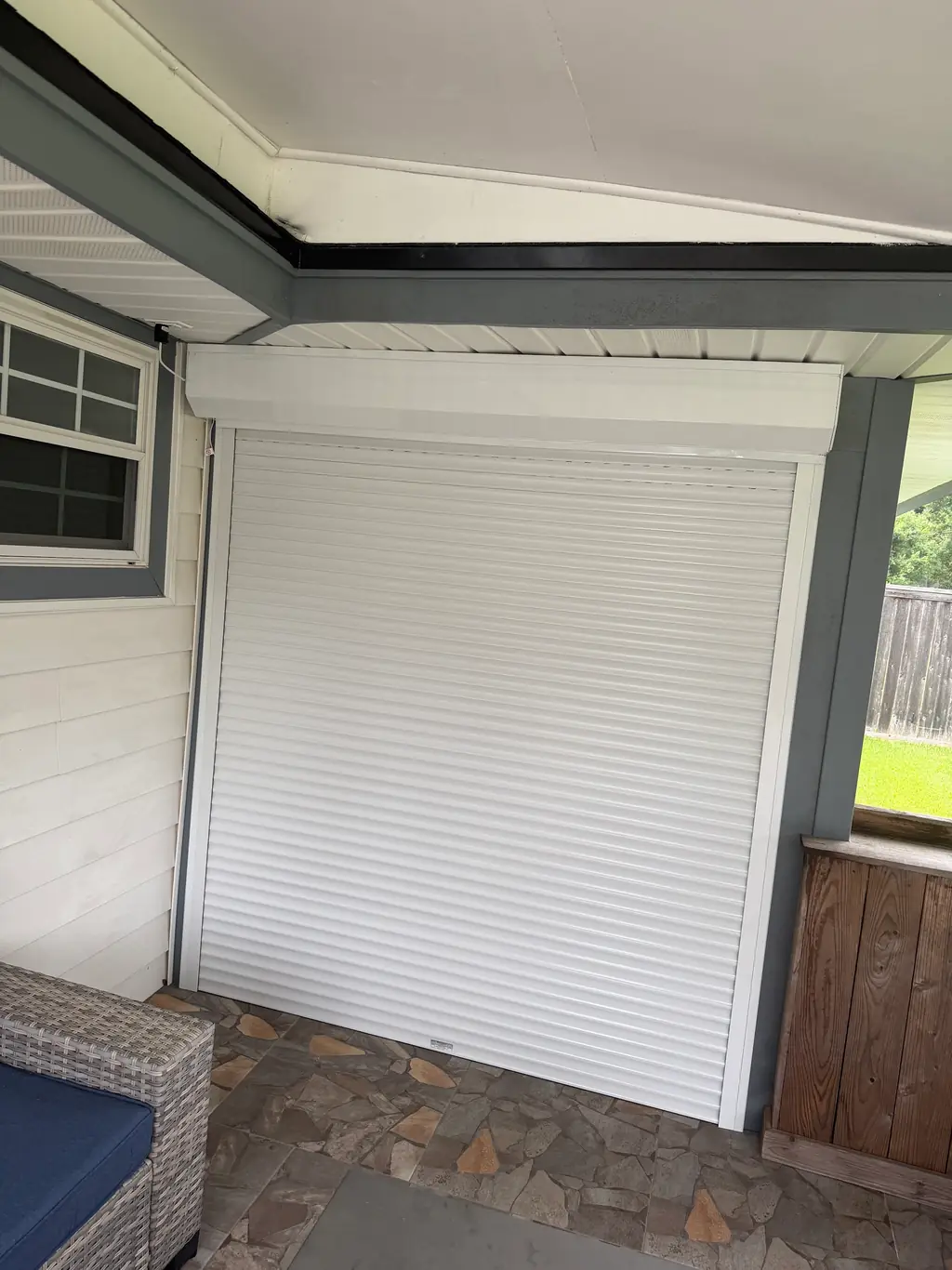 A rolling hurricane shutter housing above a covered patio opening on a southeast Texas home